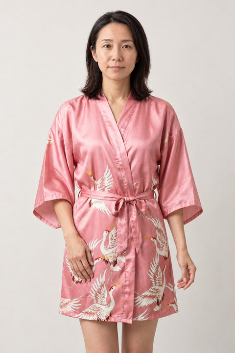 Pink Crane Kimono Nightgown 'Hanazuru' – pink women's short satin-look kimono nightgown with white crane print and tie belt, Japanese robe, front view on model