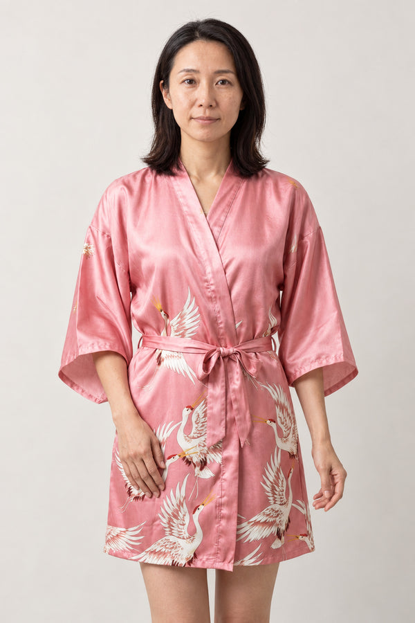 Pink Crane Kimono Nightgown 'Hanazuru' – pink women's short satin-look kimono nightgown with white crane print and tie belt, Japanese robe, front view on model