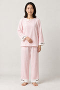 Pink Ryokan Style Pajamas 'Onsen' – pale pink women's ryokan style pyjama set with lace trim, Japanese loungewear top and trousers, front view on model