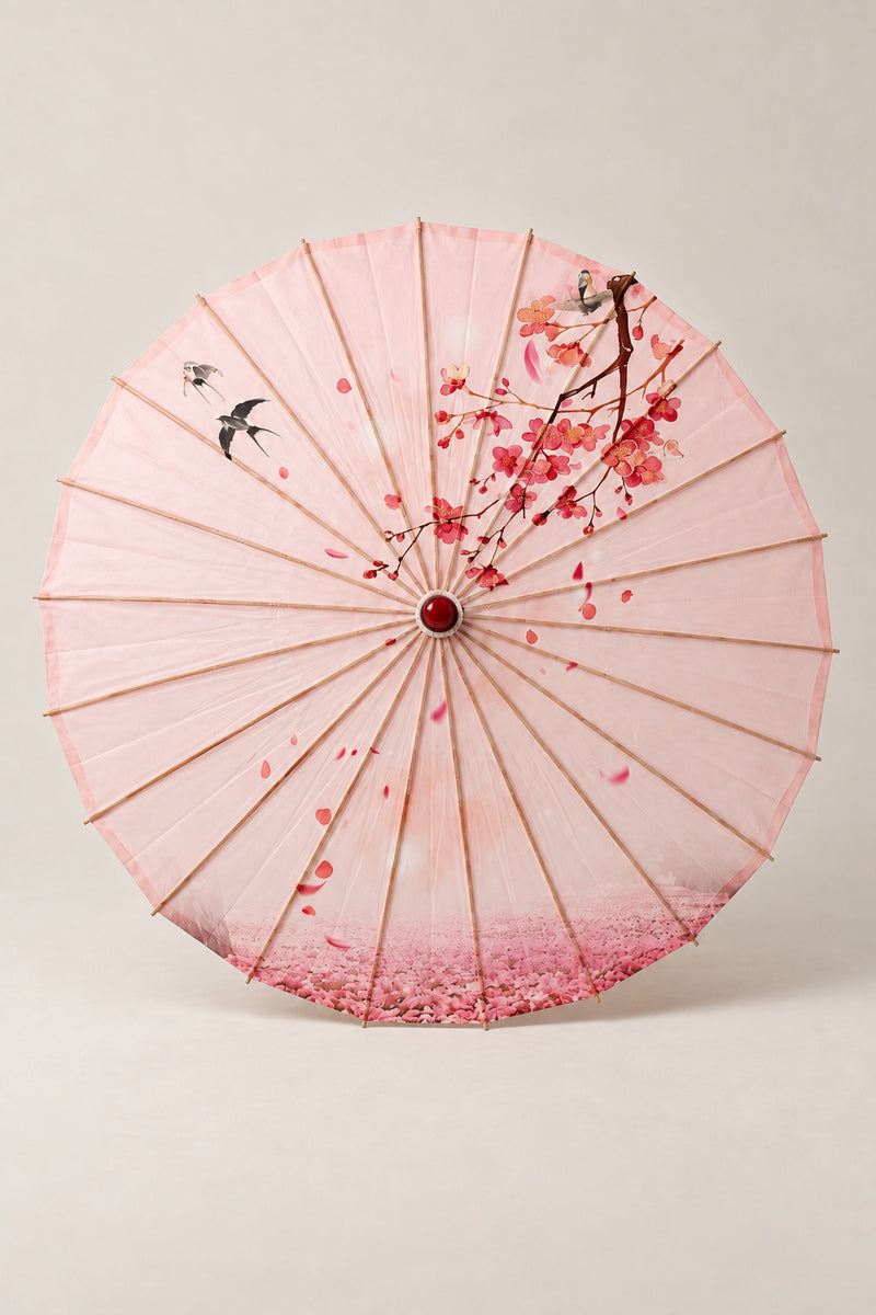 Pink Sakura Japanese Umbrella 'Sakurairo' – pink parasol printed with cherry blossom branches and falling petals, Japanese wagasa parasol with wooden frame and paper-effect canopy, open, studio view