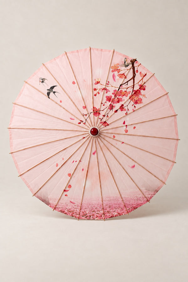 Pink Sakura Japanese Umbrella 'Sakurairo' – pink parasol printed with cherry blossom branches and falling petals, Japanese wagasa parasol with wooden frame and paper-effect canopy, open, studio view