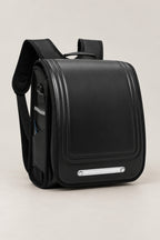 Randoseru – black randoseru Japanese school backpack with long flap and metal plate, front view, studio