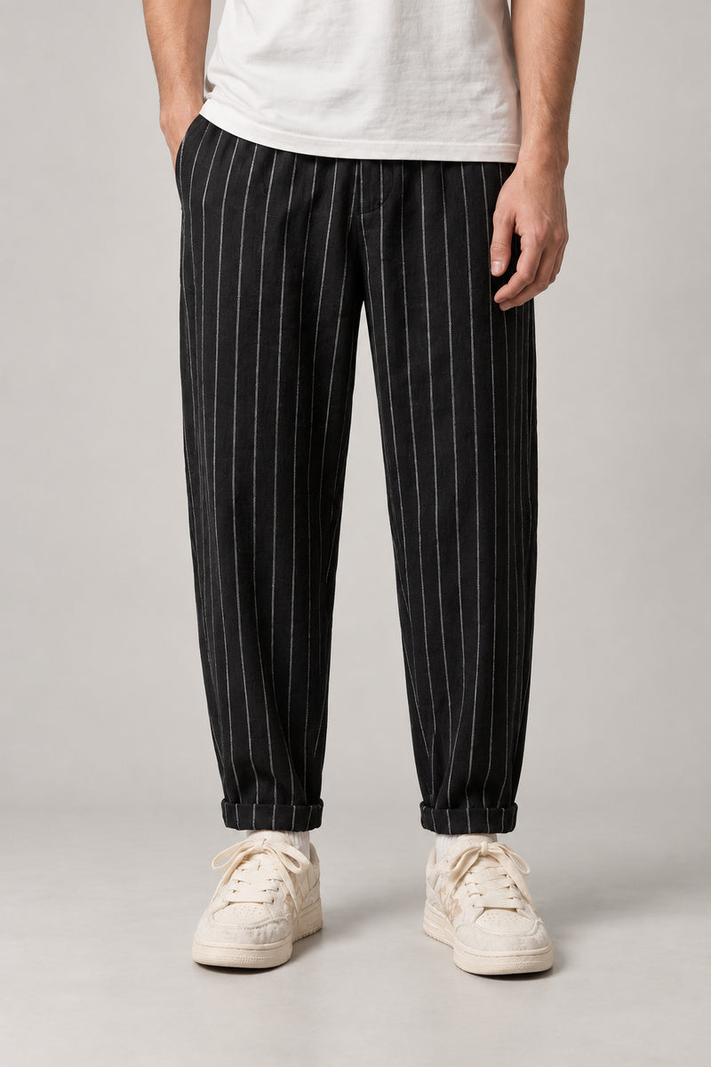 Relaxed Pinstripe Trousers 'Hosojima' – black pinstripe relaxed trousers with elastic waist, Japanese streetwear pants, front view on model