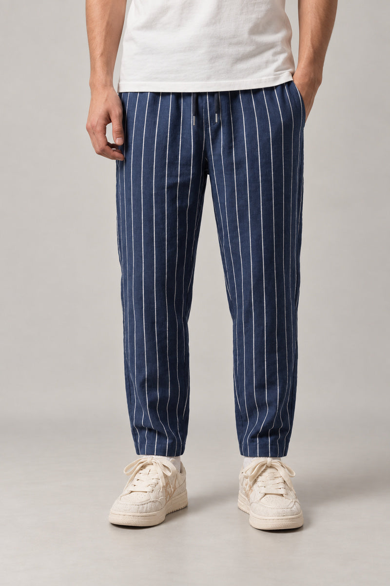 Relaxed Pinstripe Trousers 'Hosojima' – navy pinstripe relaxed trousers with cuffed hem, front view on model