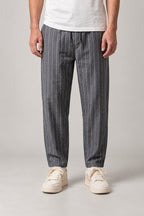 Relaxed Pinstripe Trousers 'Hosojima' – grey pinstripe relaxed trousers with cuffed hem, front view on model