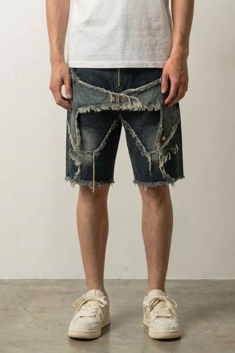 Ripped and Patched Denim Shorts 'Yabure' – dark blue ripped and patched denim shorts with frayed star panels, front view on model, studio