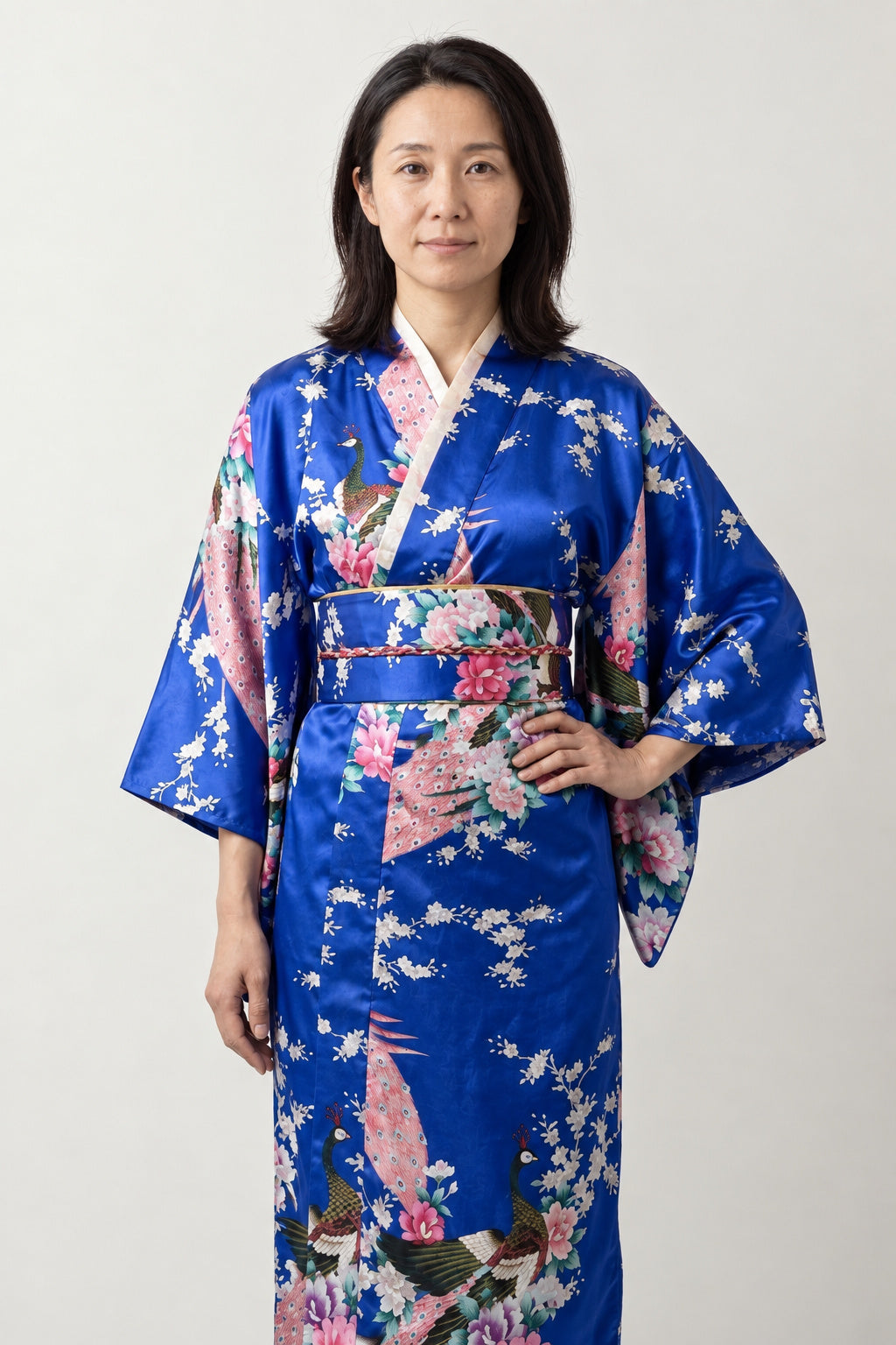 Royal Blue Peacock Kimono 'Ruri' – royal blue women's kimono robe with peacock and cherry blossom print and matching obi, long Japanese satin-look kimono, front view on model