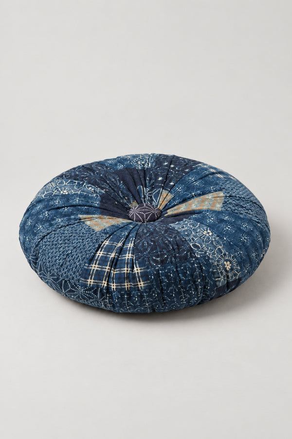 Sashiko Patchwork Round Cushion 'Tsugihagiza' – navy segmented round cushion pieced from indigo prints with sashiko stitching, pumpkin style Japanese patchwork floor cushion, studio view