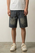Spider Web Print Denim Shorts 'Kumonosu' – dark washed denim shorts with spider web and spider print, front view on model, studio