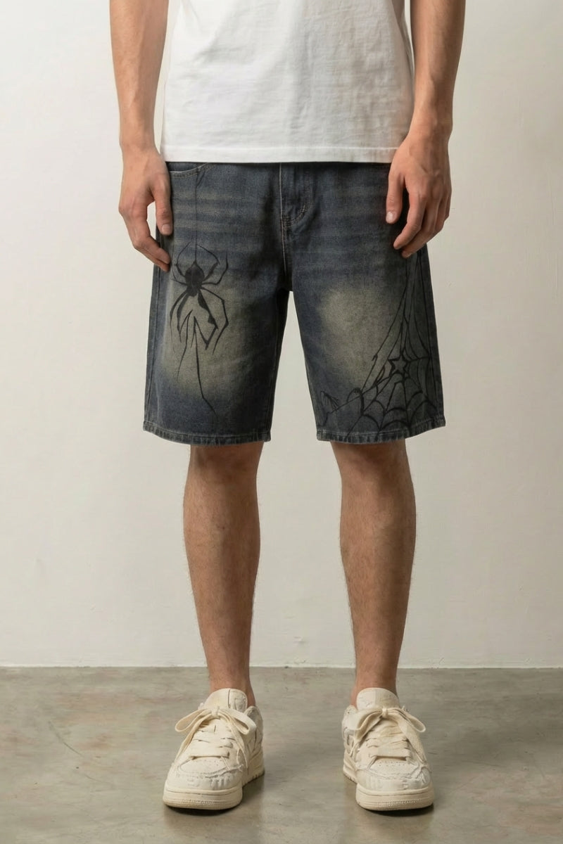 Spider Web Print Denim Shorts 'Kumonosu' – dark washed denim shorts with spider web and spider print, front view on model, studio
