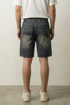 Spider Web Print Denim Shorts 'Kumonosu' – back view on model, studio