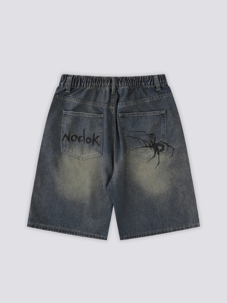 Spider Web Print Denim Shorts 'Kumonosu' – flat lay back view of the dark washed denim shorts