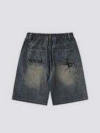 Spider Web Print Denim Shorts 'Kumonosu' – flat lay back view of the dark washed denim shorts