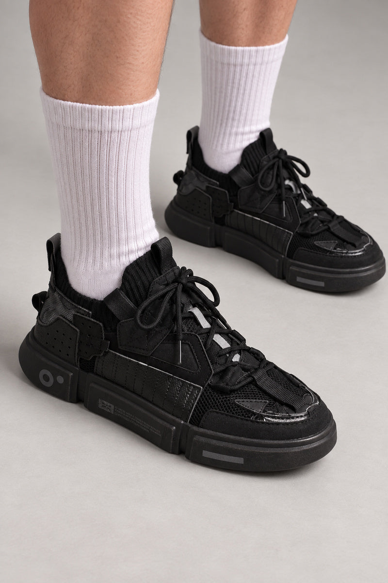 Strapped Utility Chunky Sneakers 'Yoroi' – all black chunky utility sneakers with straps and thick sole, Japanese streetwear sneakers worn with white socks, on model