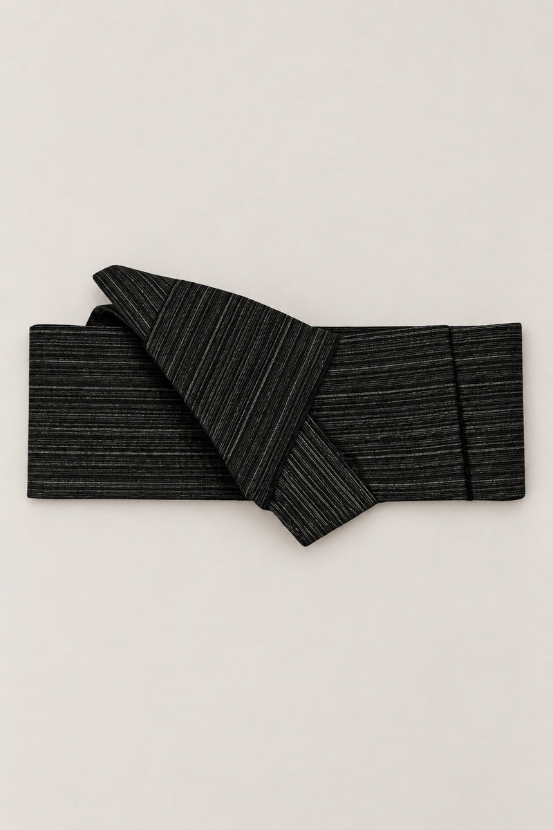 Striated Black Obi Style Belt 'Hosome' – black obi belt striated in fine grey lines, narrow pre-tied Japanese obi belt with sewn knot and hidden adjustable closure, for kimono, yukata or jinbei, studio view