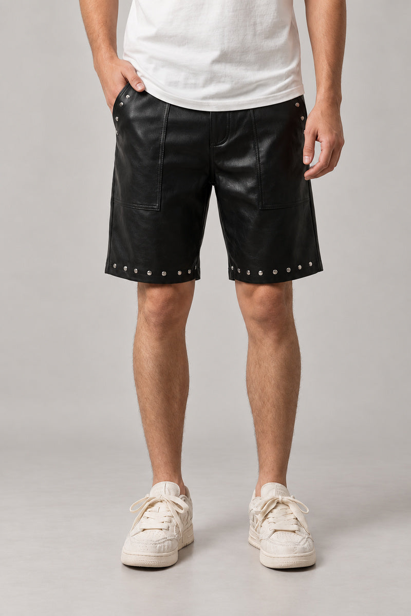 Studded Faux Leather Shorts 'Byo' – black studded faux leather shorts with silver studs at the hem, Japanese streetwear shorts, front view on model