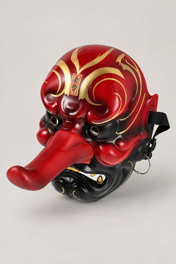 Tengu Mask 'Karasu' – red and black glossy tengu mask with long nose, gold swirls and paper charm, Japanese tengu goblin mask, studio view