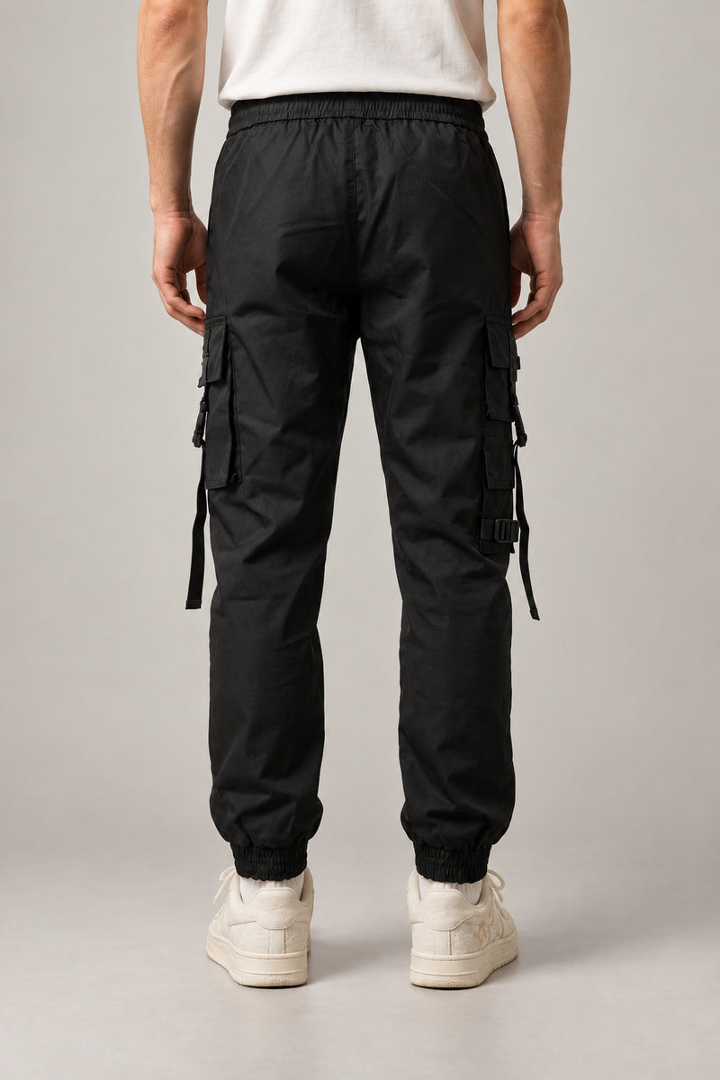 Utility Pocket Cargo Joggers 'Tetsu' – black cargo joggers with hanging straps and buckles, front view on model