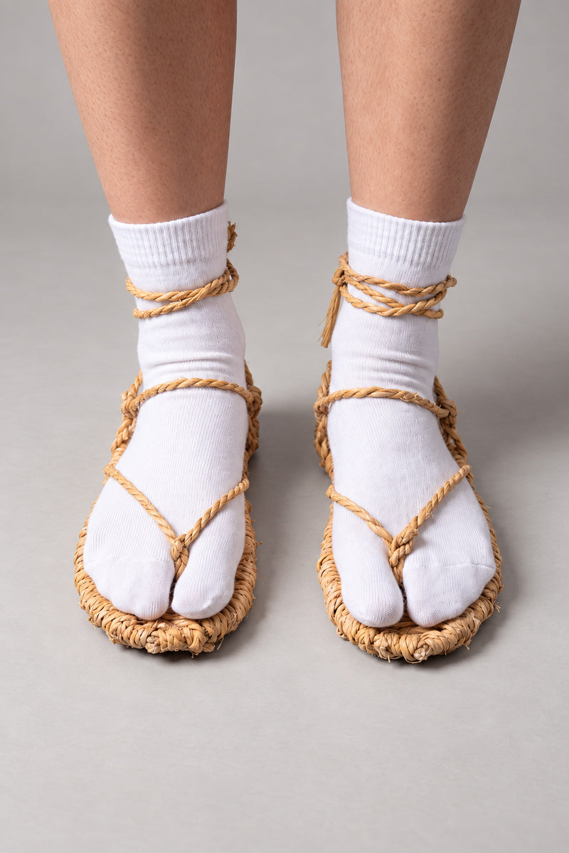 Waraji Sandals – Japanese waraji straw sandals worn over white split-toe tabi socks, front view on model