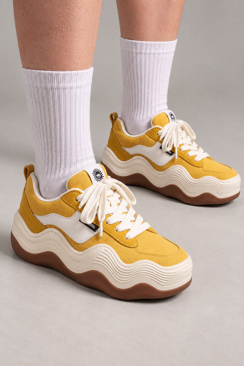 Wavy Platform Sole Sneakers 'Uneri' – mustard yellow platform sneakers on a wavy cream and gum sole, Japanese streetwear sneakers worn with white socks, on model