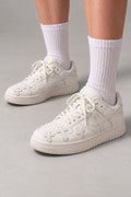 White Cross Patch Sneakers 'Jujika' – all white skate sneakers with tonal cross patches, Japanese streetwear sneakers worn with white socks, on model