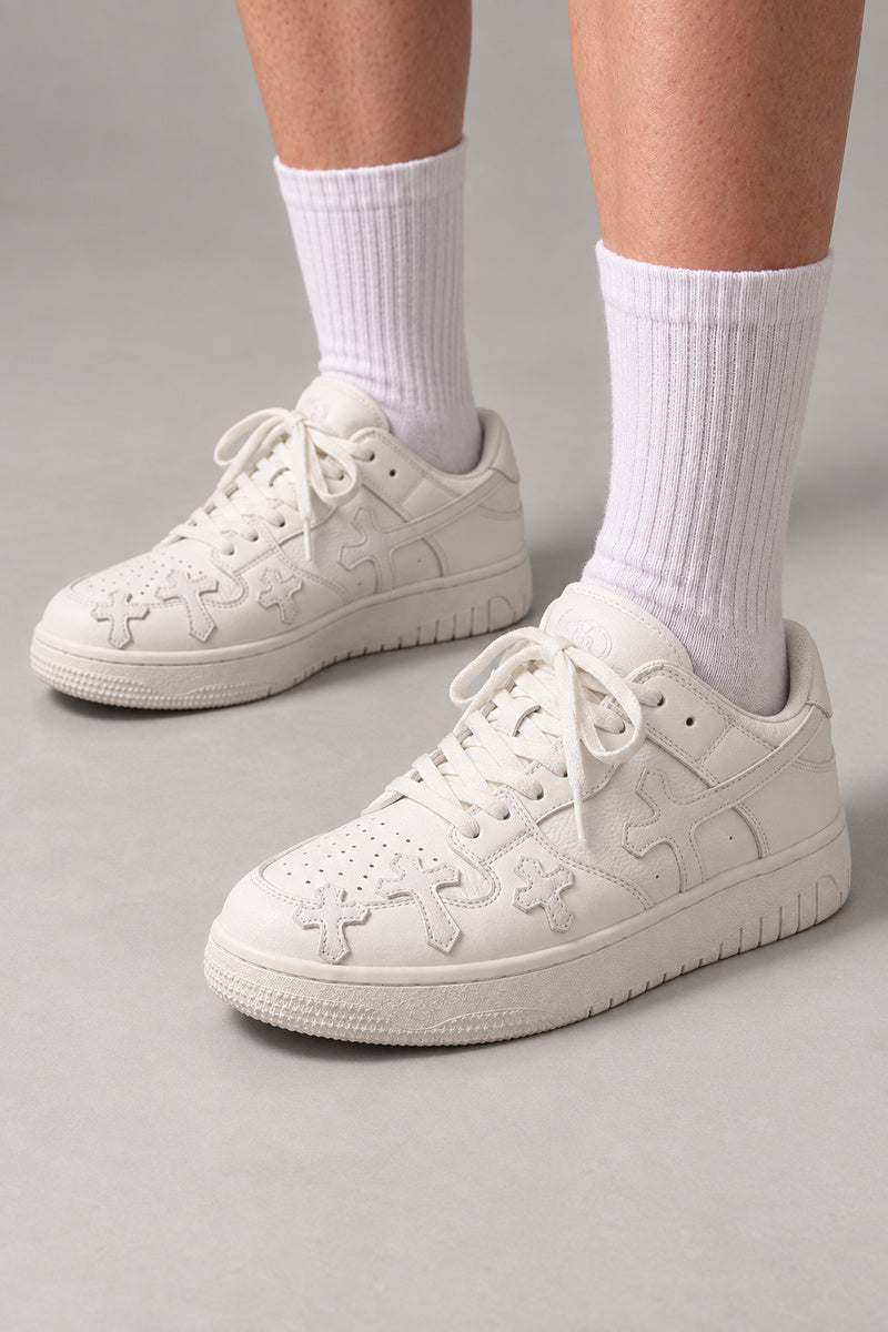 White Cross Patch Sneakers 'Jujika' – all white skate sneakers with tonal cross patches, Japanese streetwear sneakers worn with white socks, on model