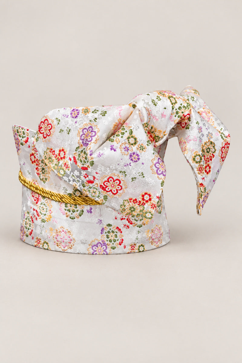 White Floral Brocade Obi 'Kohana' – white brocade obi with small red, purple and green flowers and gold cord, wide pre-tied brocade obi belt with sewn bow for women's kimono or yukata, studio view