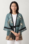 Women's Belted Kimono Robe 'Asagi' – teal blue women's belted kimono robe with white crane print and black tie, sheer Japanese kimono jacket, front view on model