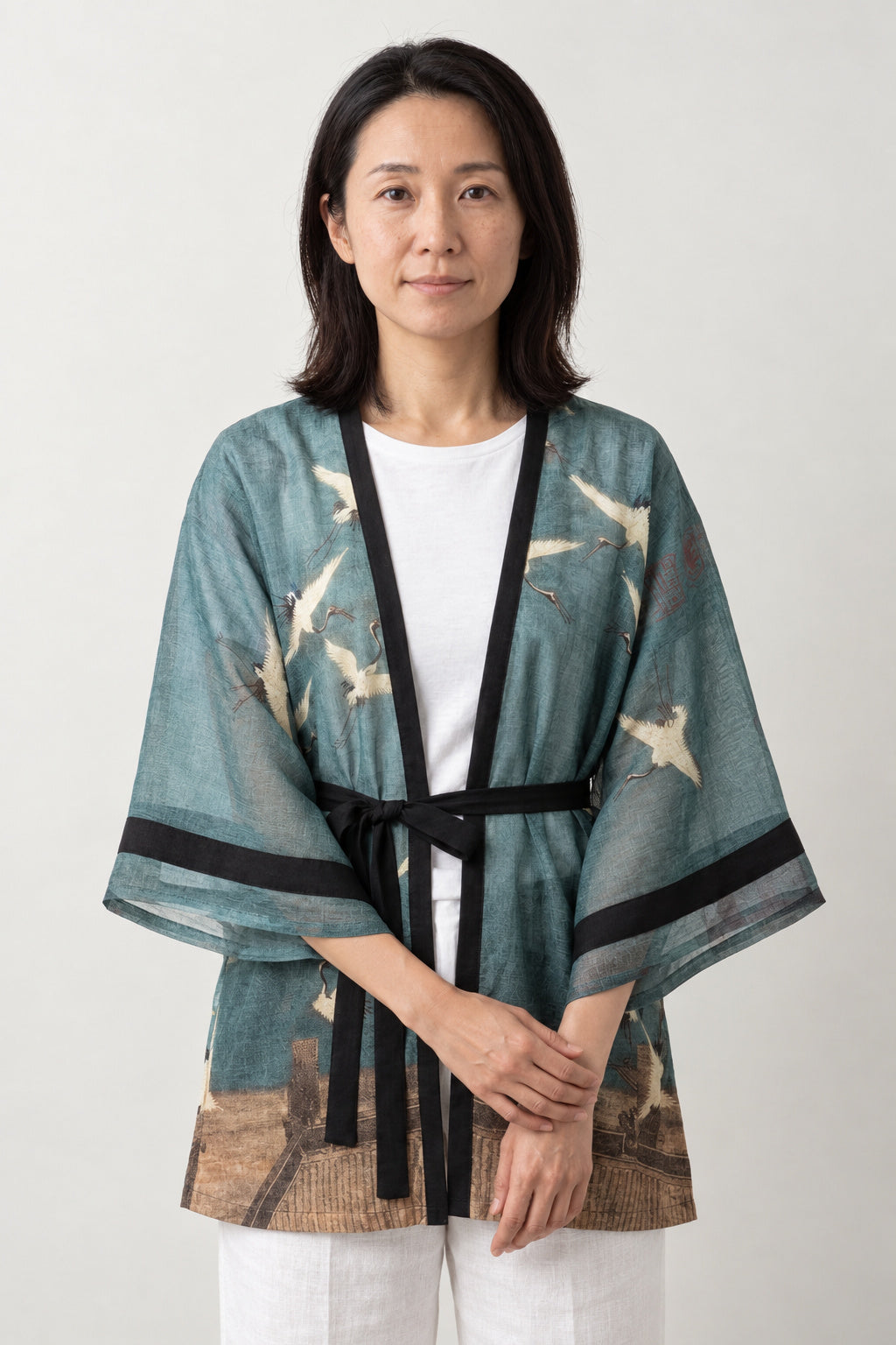 Women's Belted Kimono Robe 'Asagi' – teal blue women's belted kimono robe with white crane print and black tie, sheer Japanese kimono jacket, front view on model