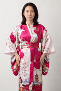 Women's Magenta Kimono Robe 'Tsutsuji' – magenta pink women's kimono robe with peacock and floral print and red obi sash, long Japanese satin-look kimono, front view on model