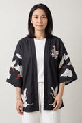 Women's Red Bird Kimono Jacket 'Akane' – black women's kimono jacket with red-crowned crane, clouds and kanji crest print, Japanese haori style cardigan, front view on model