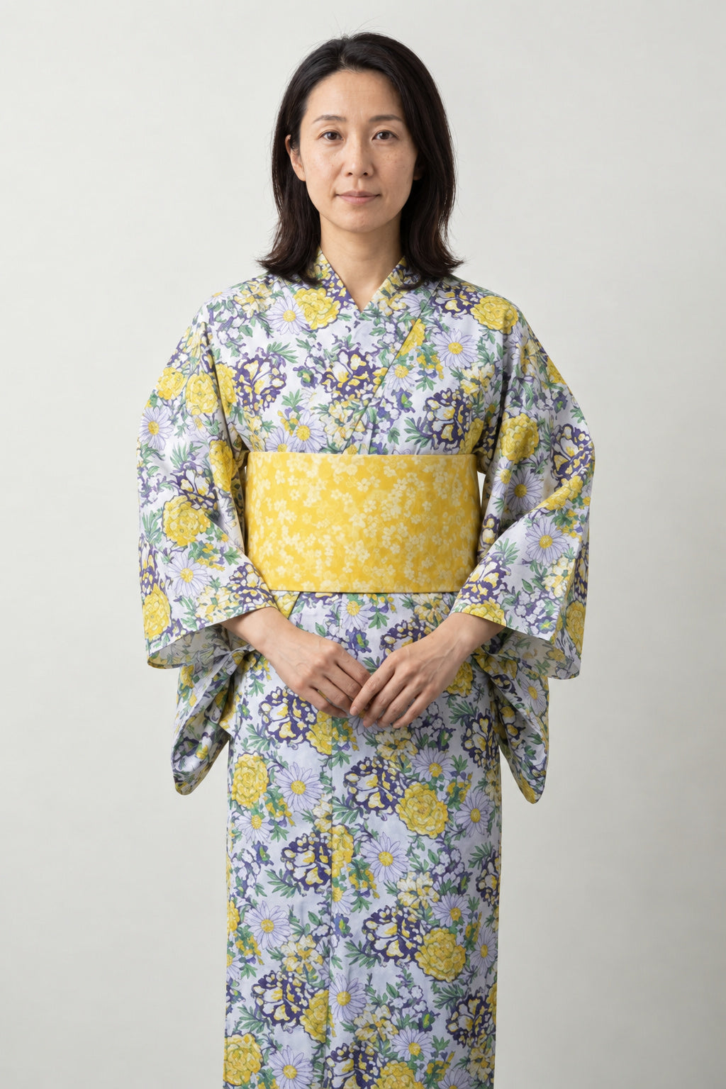 Women's Yellow Floral Kimono 'Nanohana' – white women's kimono with yellow and grey floral print and yellow obi belt, traditional Japanese yukata, front view on model
