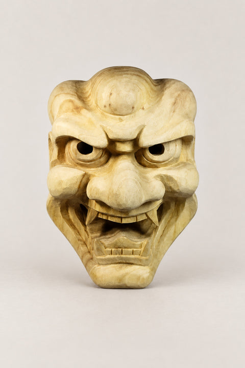 Wooden Japanese Mask 'Ikkoku' – unpainted wooden demon mask with knotted brow, deep eyes and bared teeth, hand carved wooden Japanese mask for the wall, studio view