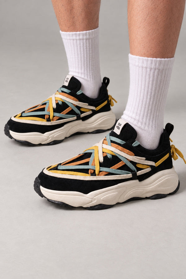 Woven Lace Chunky Sneakers 'Kumiito' – black chunky sneakers laced with multicolour woven straps, Japanese streetwear sneakers worn with white socks, on model