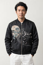 Yokai Crest Bomber Jacket 'Kamon' – black bomber jacket with embroidered dragon crest and blossom, Japanese streetwear, front view on model