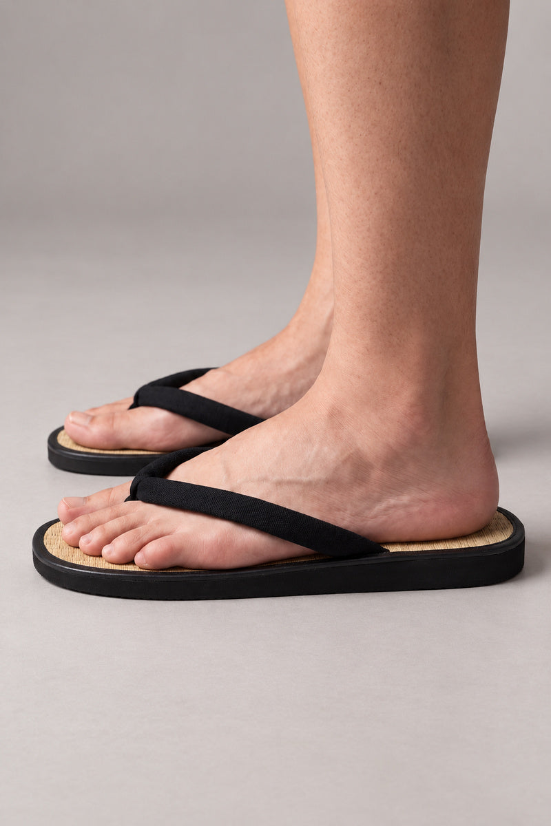 Zori sandals – black Japanese zori sandals with woven footbed, worn barefoot, side view on model